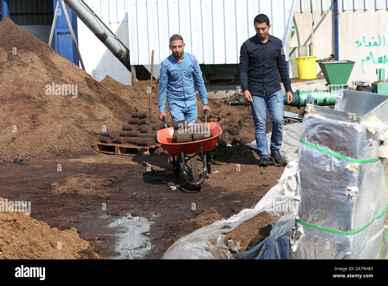 Palestinians make molds from olive pomace that is obtained from the olive oil extraction process and used as an energy source, in the Gaza Strip Stock Photo