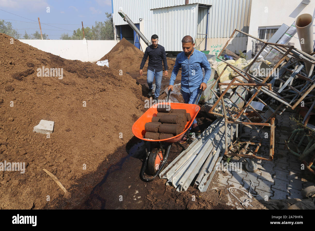 Palestinians make molds from olive pomace that is obtained from the olive oil extraction process and used as an energy source, in the Gaza Strip Stock Photo