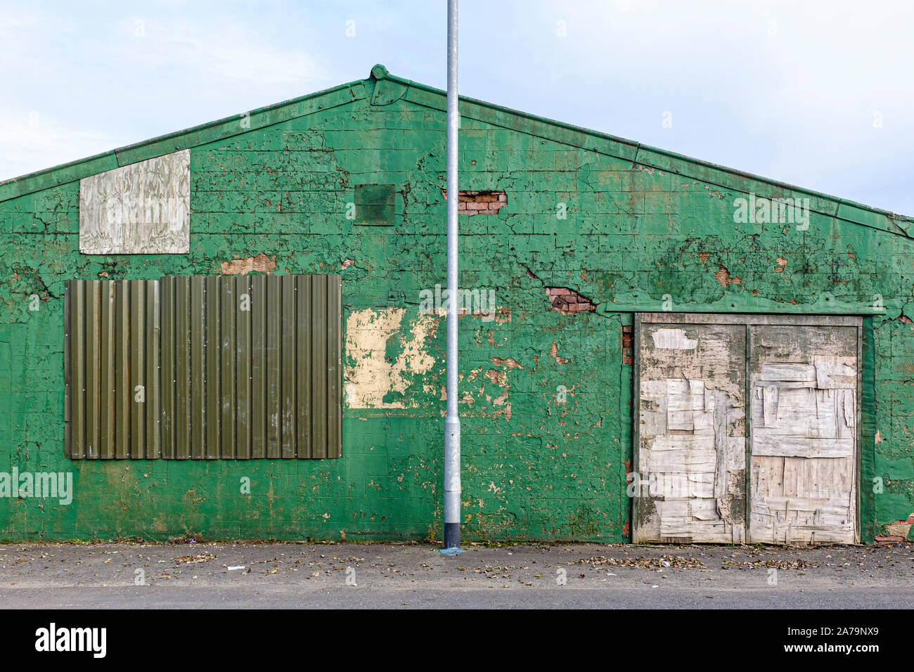Old green derelict industrial work sheds. Stock Photo