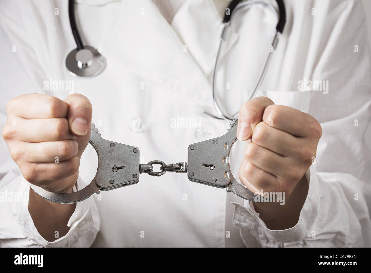 Handcuffed doctor, close-up. Medical malpractice and error concept Stock Photo