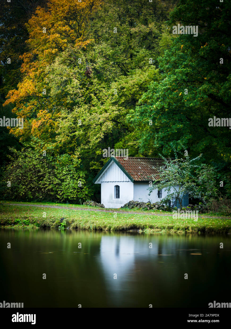 A small house in a lake front with reflection. Stock Photo