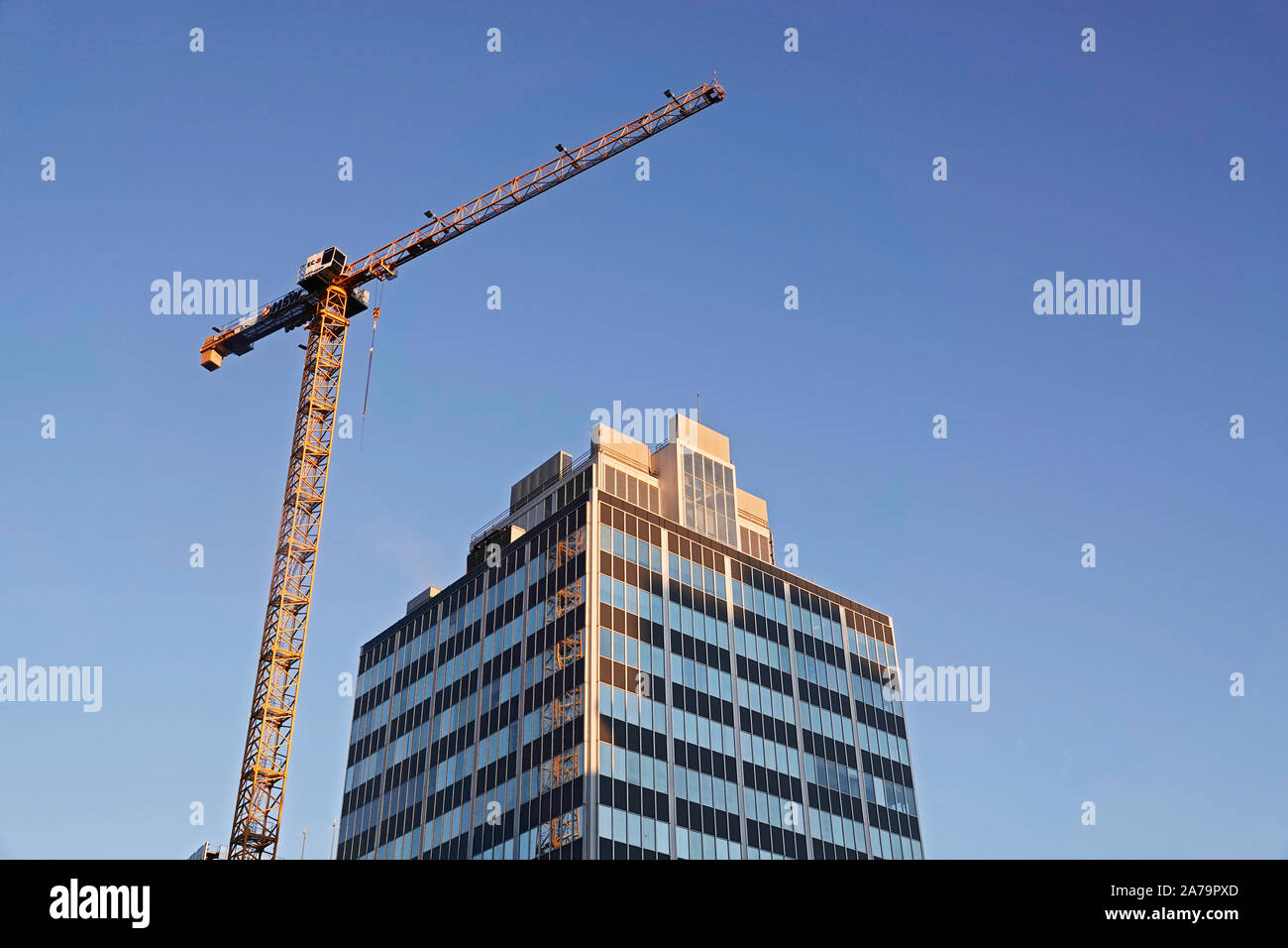 A giant building crane works on a new office building in downtown Portland, Oregon Stock Photo