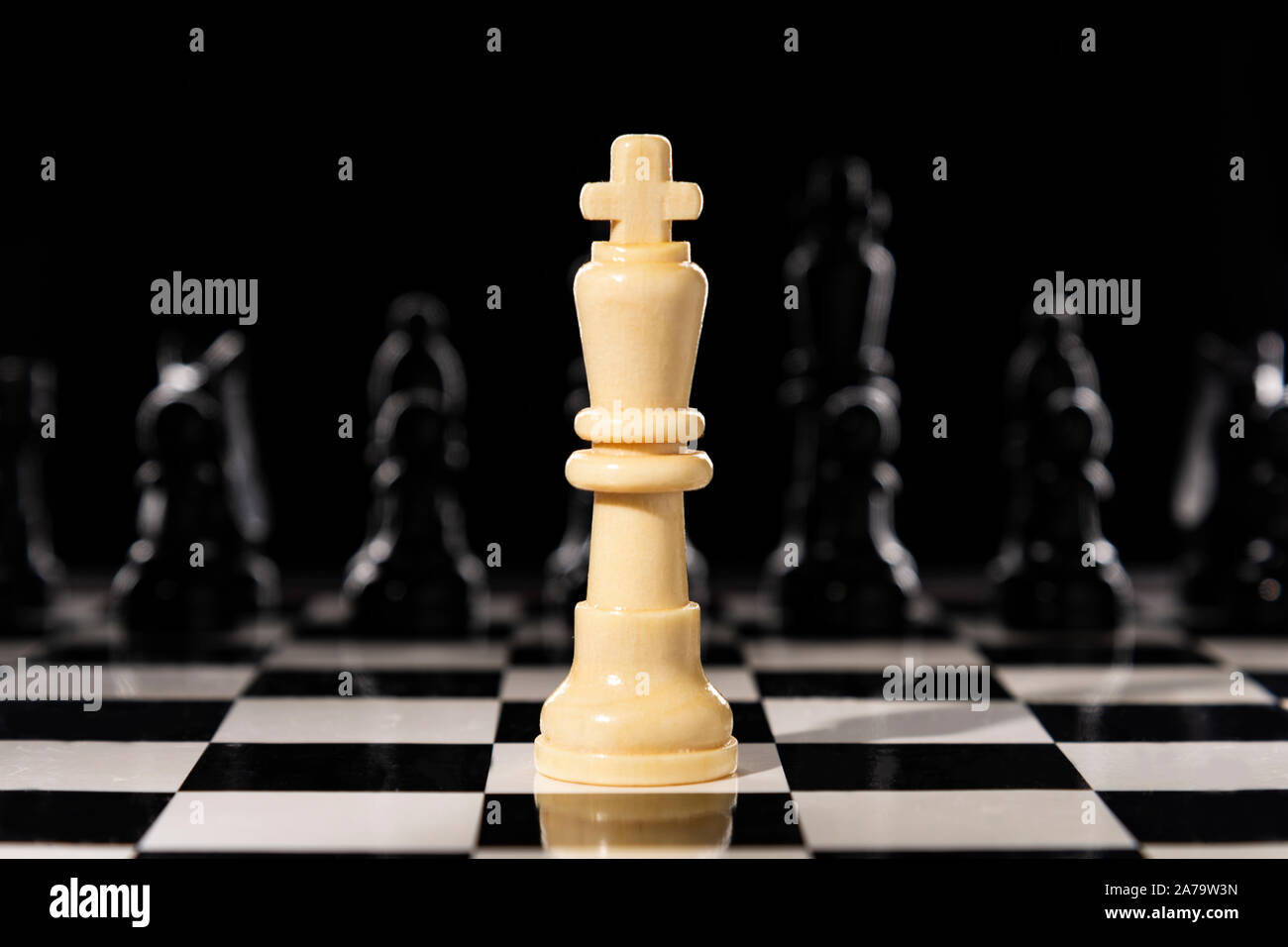 Two King chess pieces on a chessboard with the light king lying on its side  at the foot of the victorious dark wood King Stock Photo - Alamy