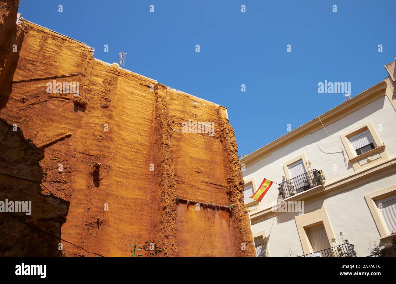 An exposed ochre coloured wall of a building under renovation in Cadiz, Andalasia, Spain. Stock Photo