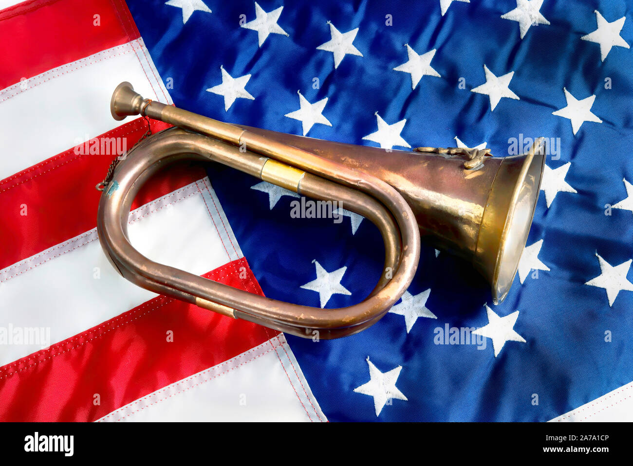 Old brass bugle on the American flag. Stock Photo