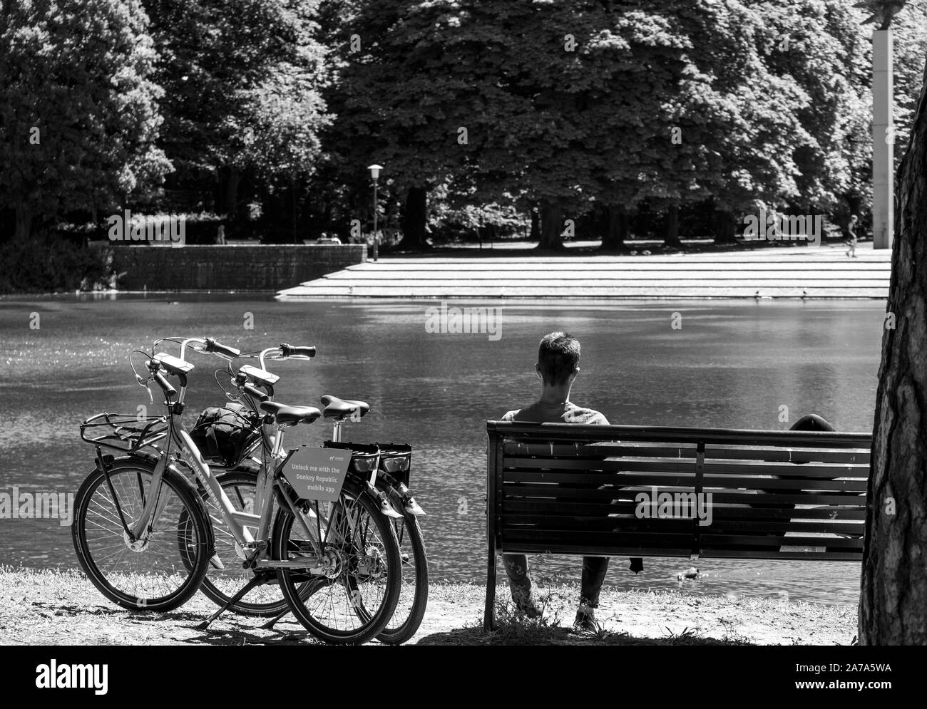 Couple in a bench resting after a long bike ride on rented bikes in Malmö, Sweden Stock Photo