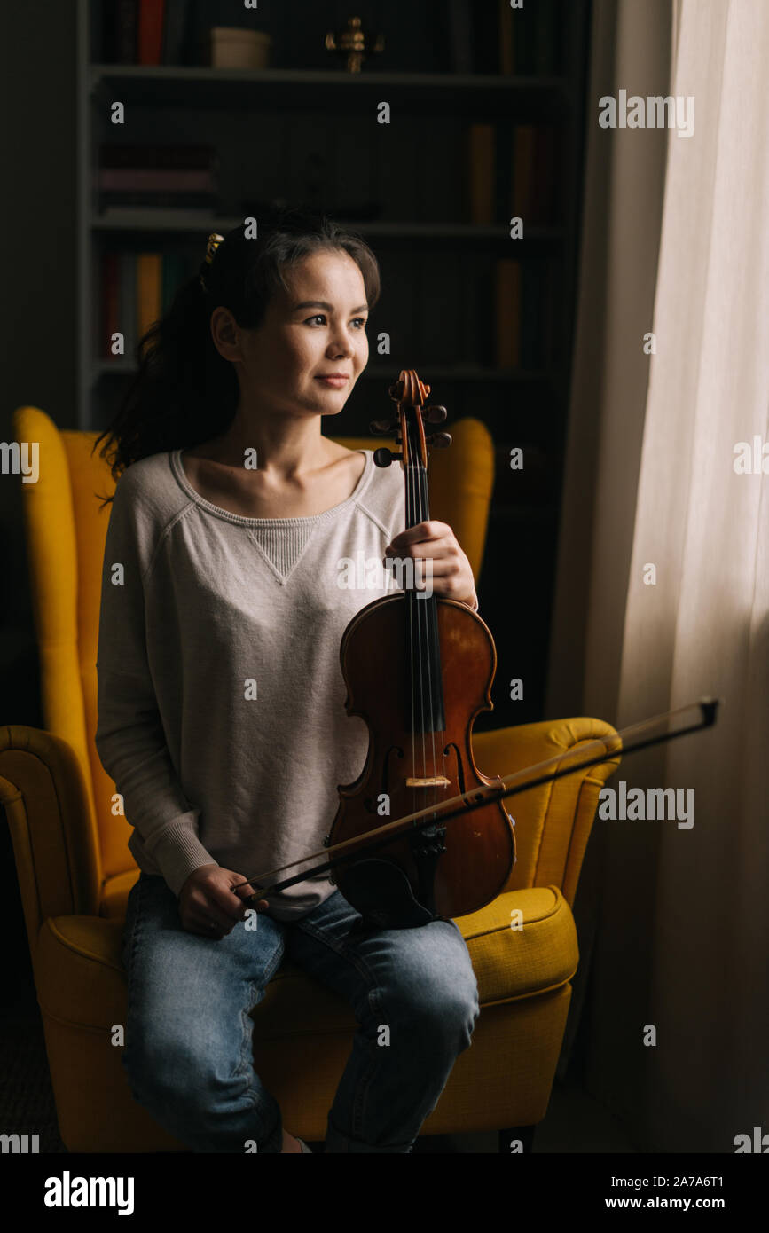 Beautiful young woman posing with a violin in her hand Stock Photo - Alamy