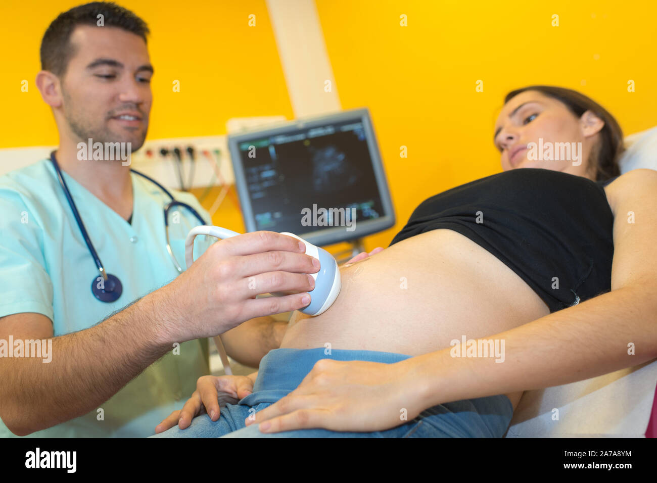 Doctor scanning pregnant woman's abdomen Stock Photo - Alamy