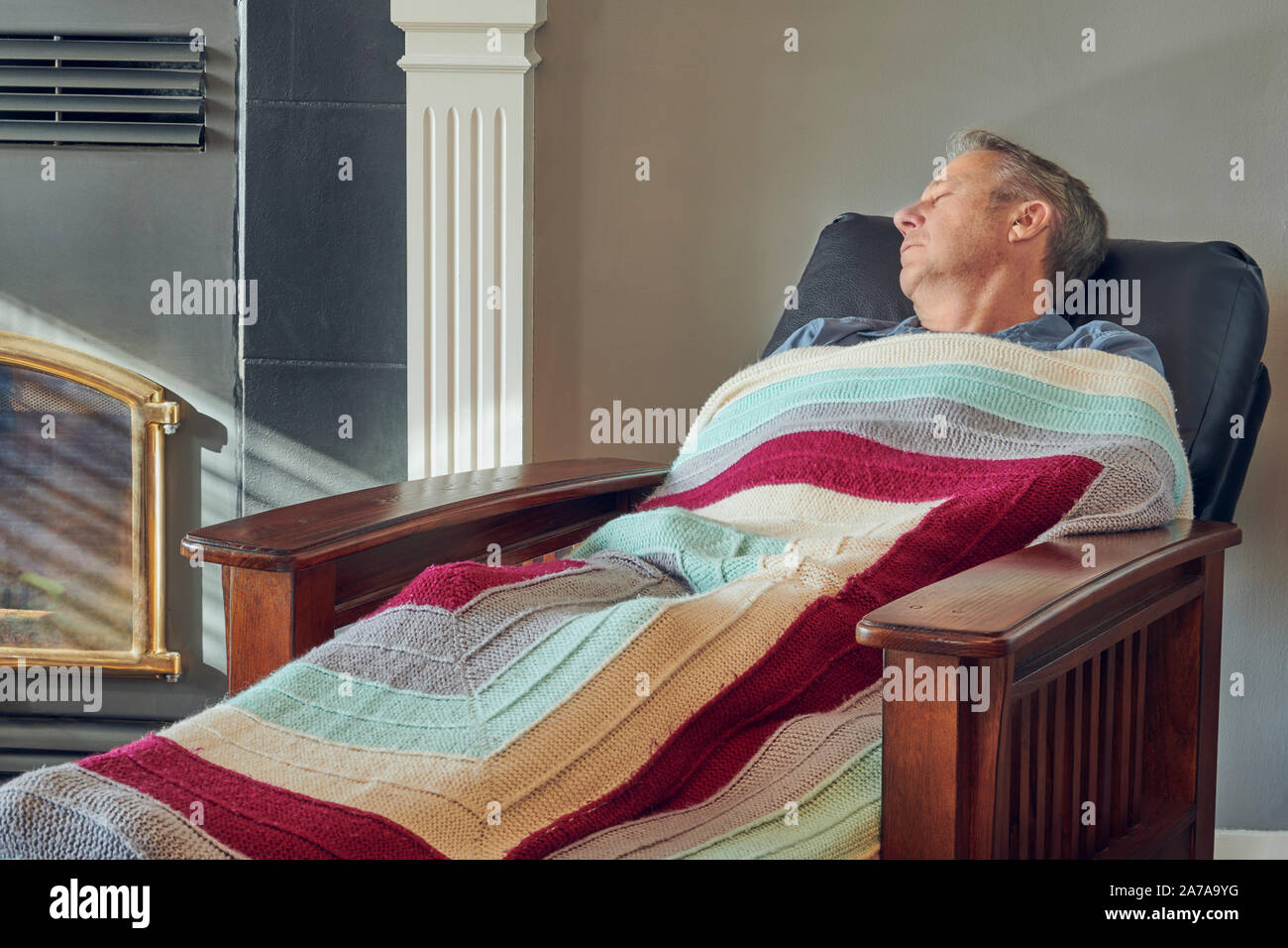 Senior male sitting on a recliner in his undershirt in boxers