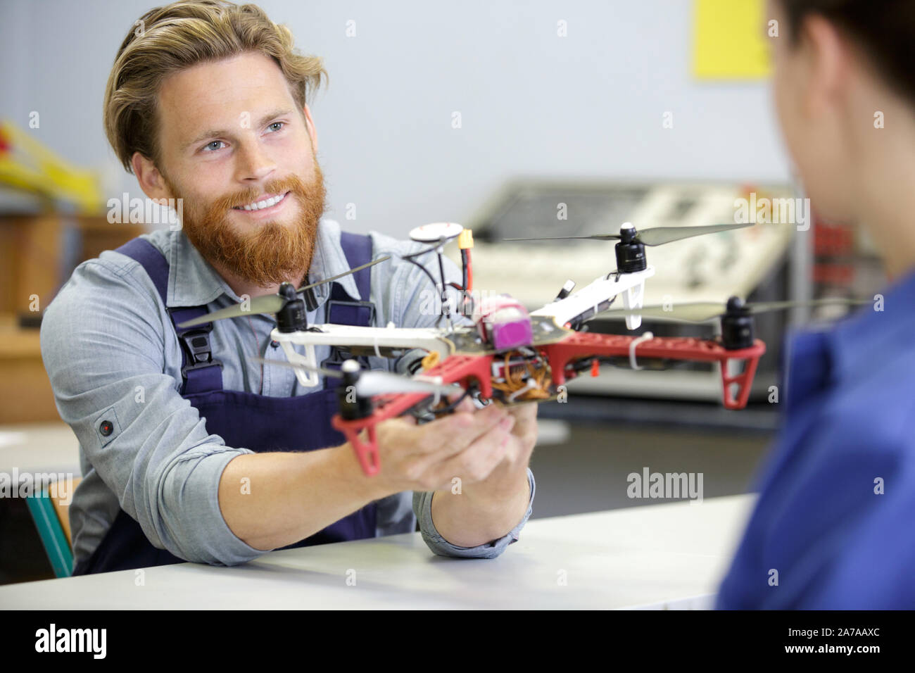 portrait of young engineer fixing propeller of octocopter indoors Stock