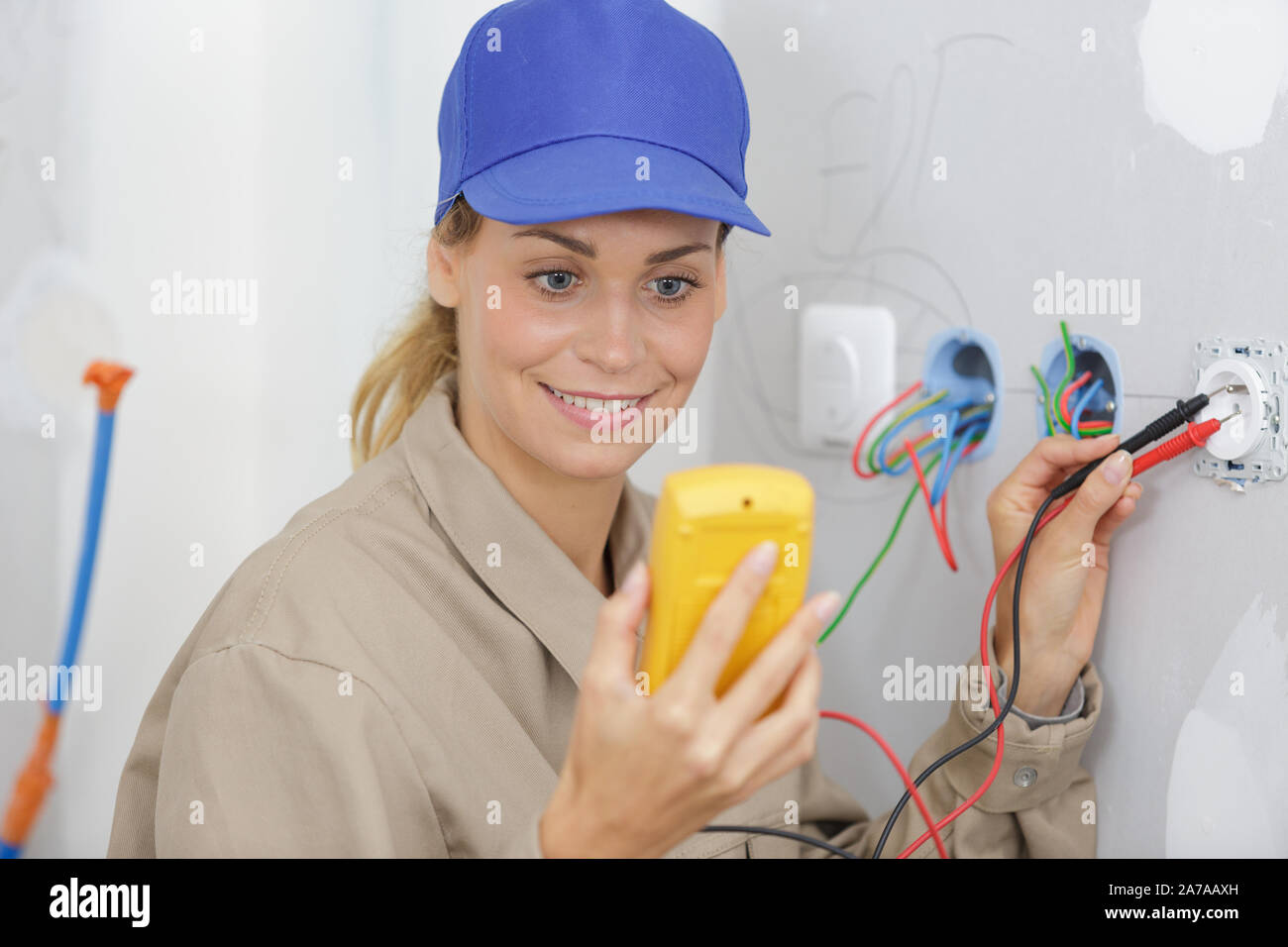 female electrician testing plug socket with multimeter Stock Photo Alamy