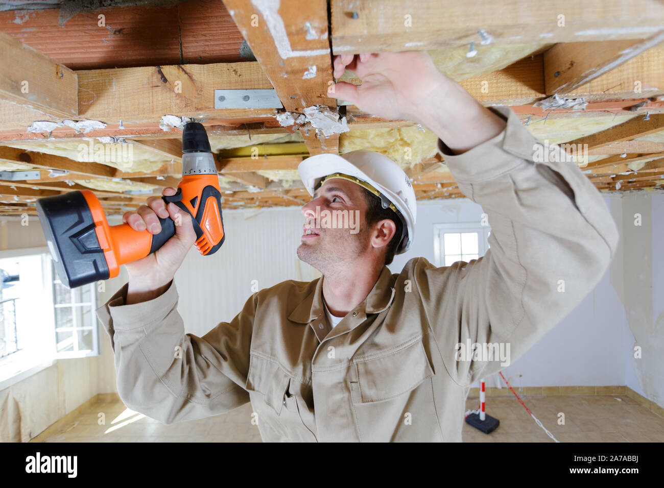 manual worker drilling ceiling with a drilling machine Stock Photo