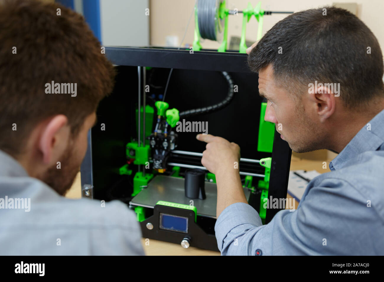 worker showing colleague a 3d printer Stock Photo