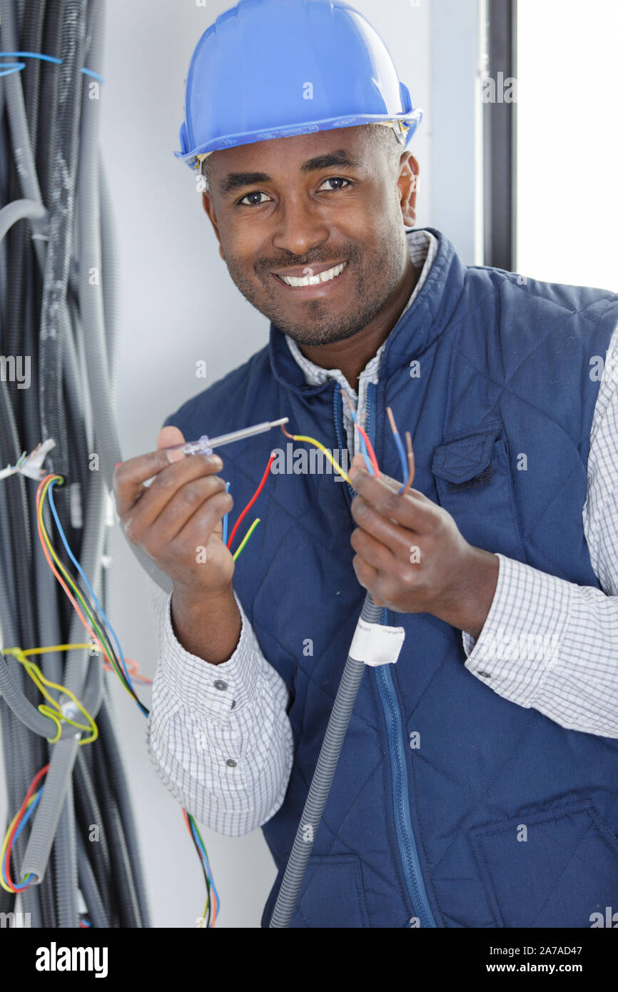 happy electrician performs electrical work Stock Photo Alamy