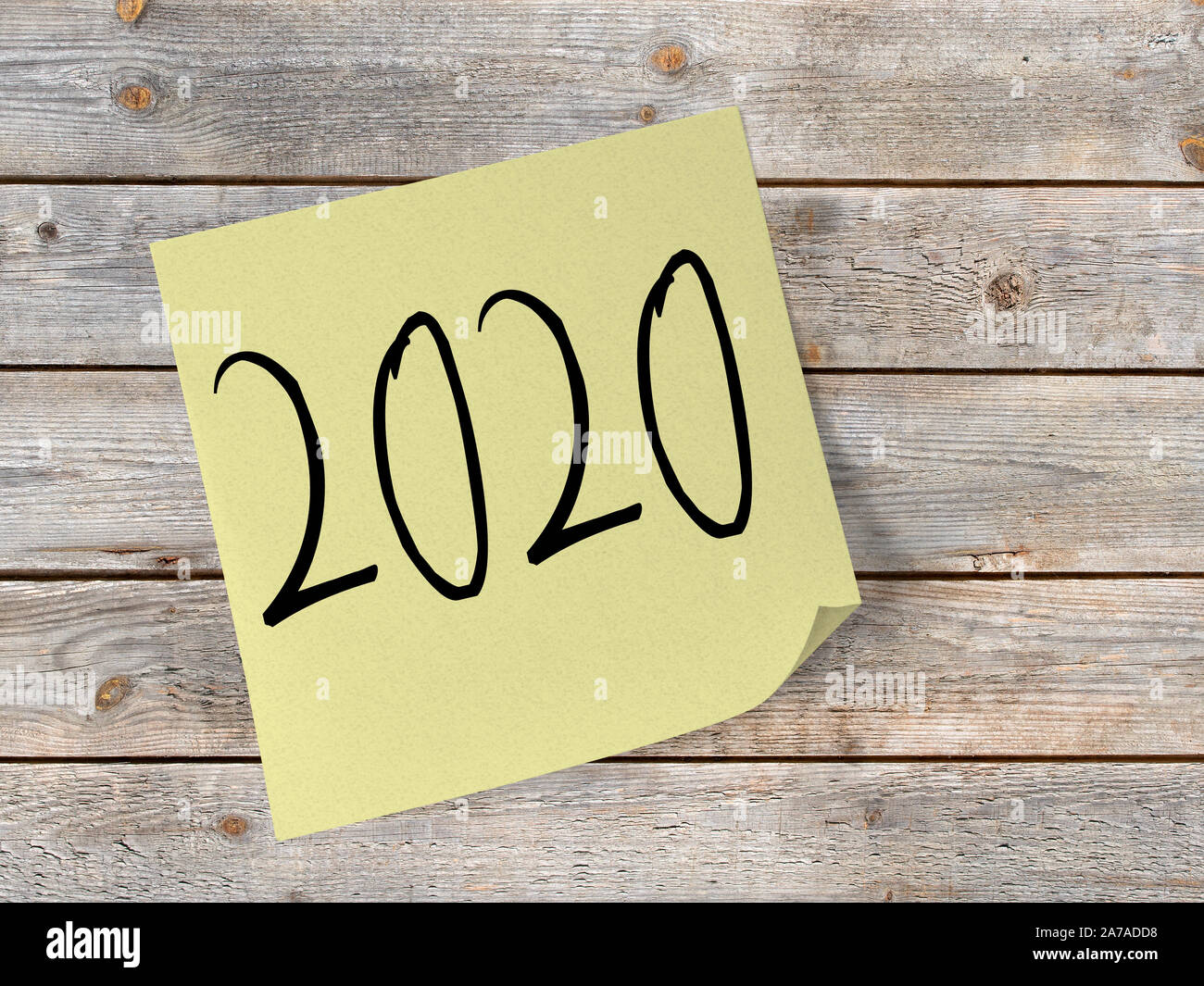 Wooden wall with sticky note with the inscription 2020 Stock Photo