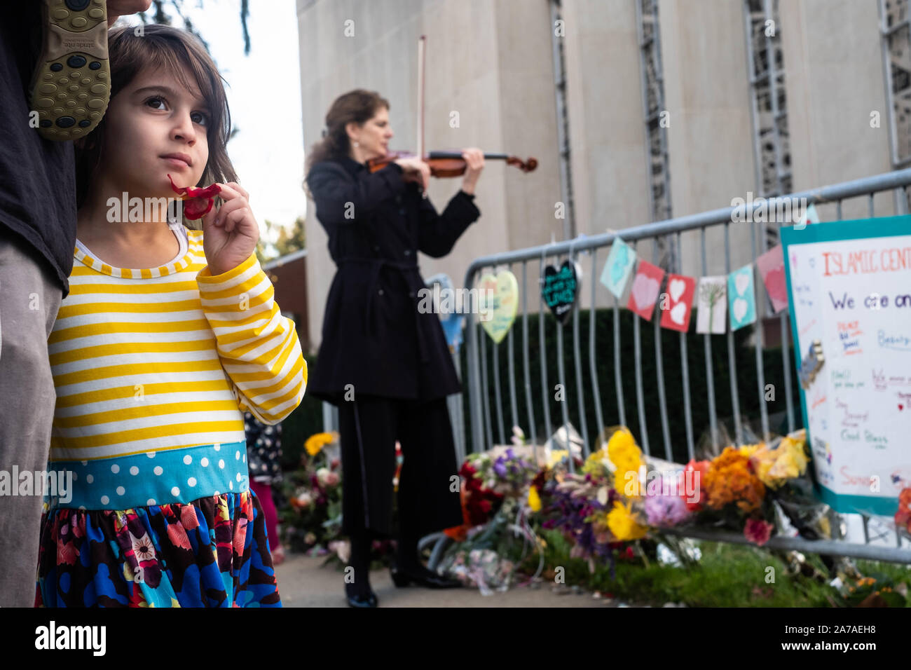 Pittsburgh, USA. 27th Oct, 2019. A girl looks on next to a woman playing a violin at memorial.One year after the shooting at the Tree of Life synagogue in Squirrel Hill, Pittsburgh, PA, many come back to the synagogue to pay their respects. Credit: Aaron Jackendoff/SOPA Images/ZUMA Wire/Alamy Live News Stock Photo