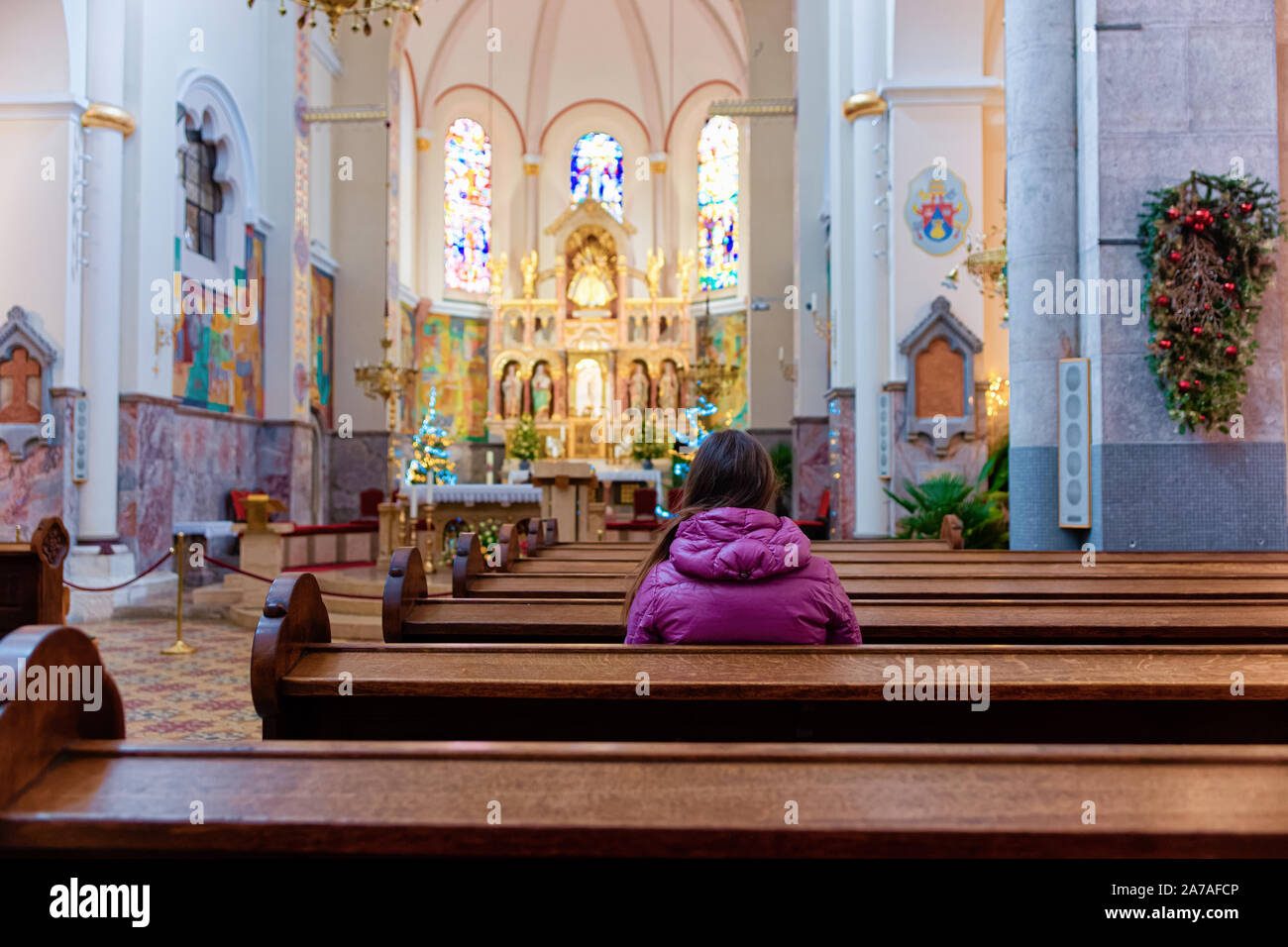Woman prayer in Franciscan church interior in Maribor Stock Photo