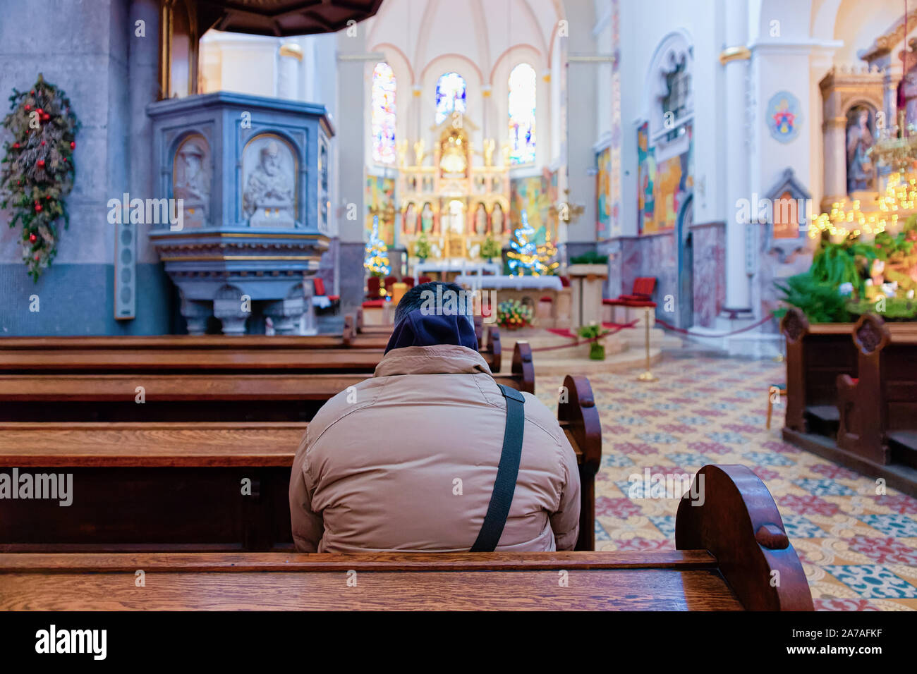 Man prayer in Franciscan church interior in Maribor Stock Photo