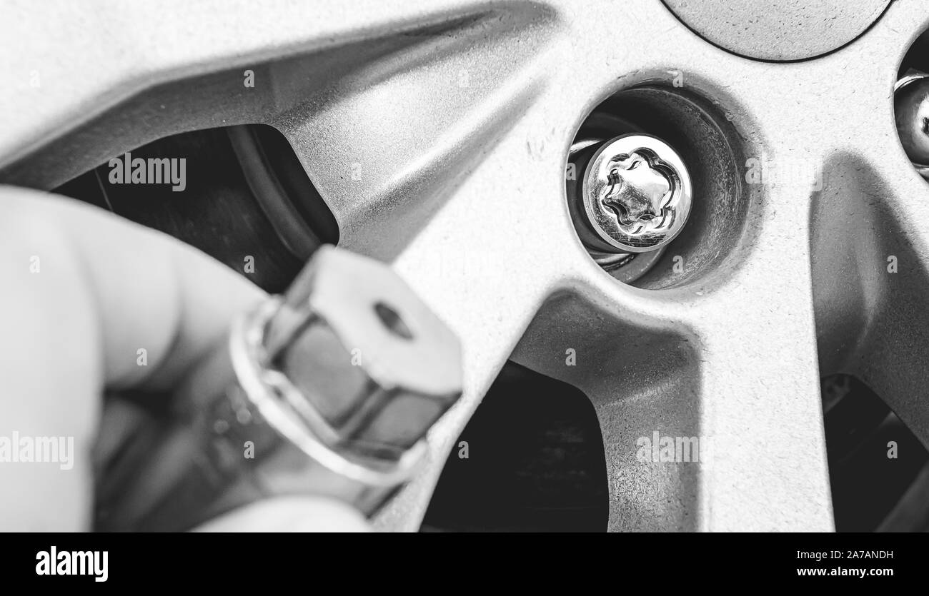 Black and white illustrative photo about the use of anti-theft wheel bolt. Stock Photo