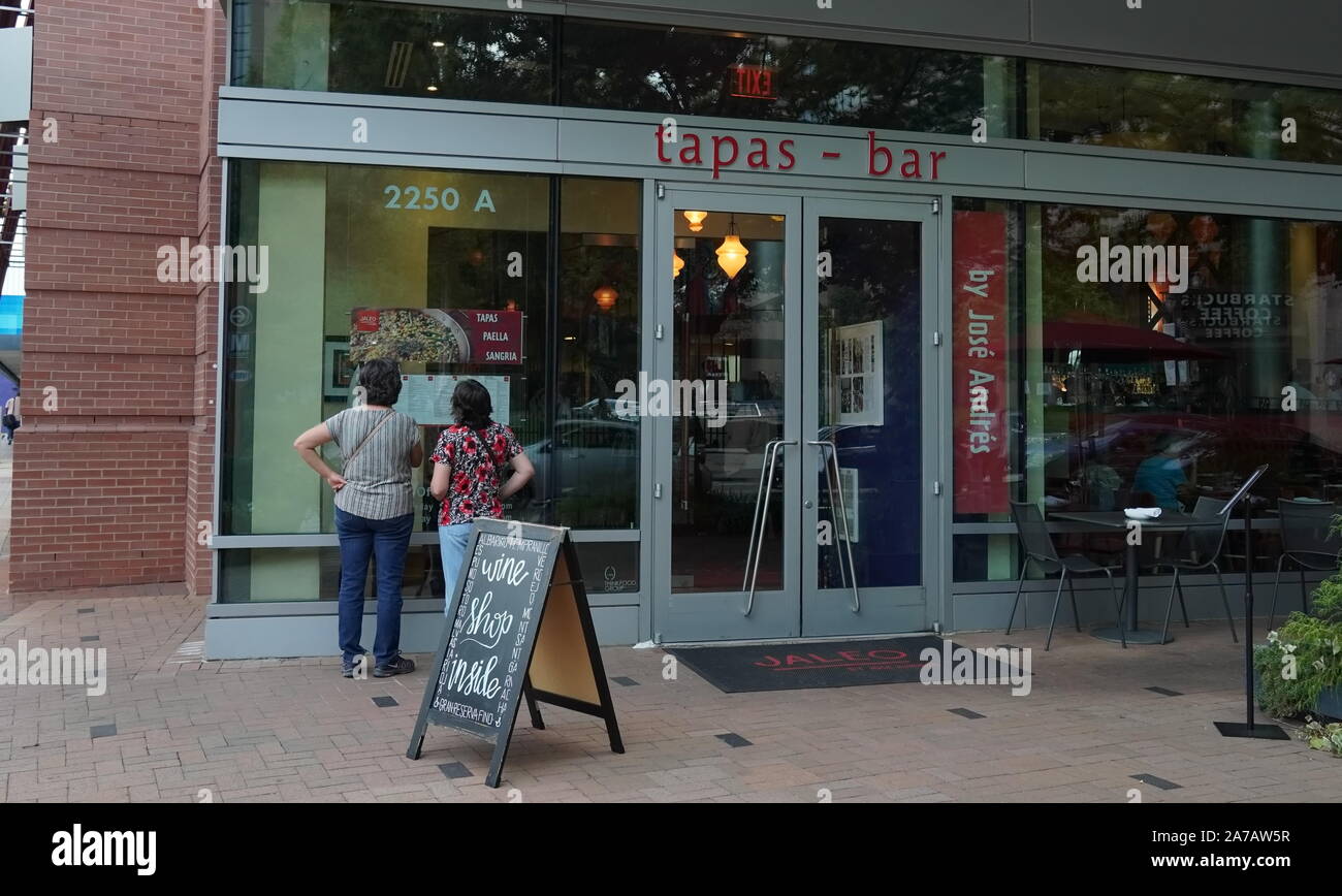 Arlington, VA / USA - September 23, 2019: Two women look at the menu in front of a tapas restaurant, in search of the next meal Stock Photo