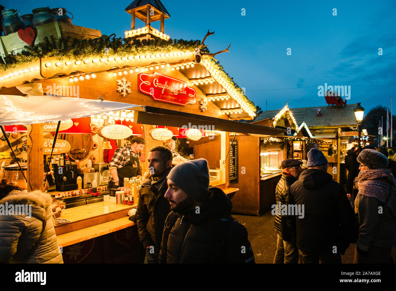 Strasbourg, France - Dec 9, 2016: Tourists and locals passing by a stall in the mythical Christmas market proposing traditional waffles, pancakes and mulled wine Stock Photo