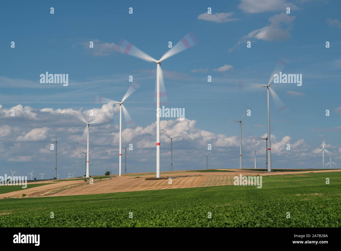 Wind turbines on the fields under a blue sky with some clouds Stock ...