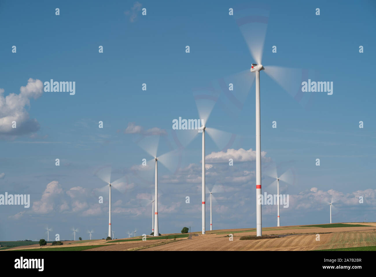 Wind turbines on the fields under a blue sky with some clouds Stock ...