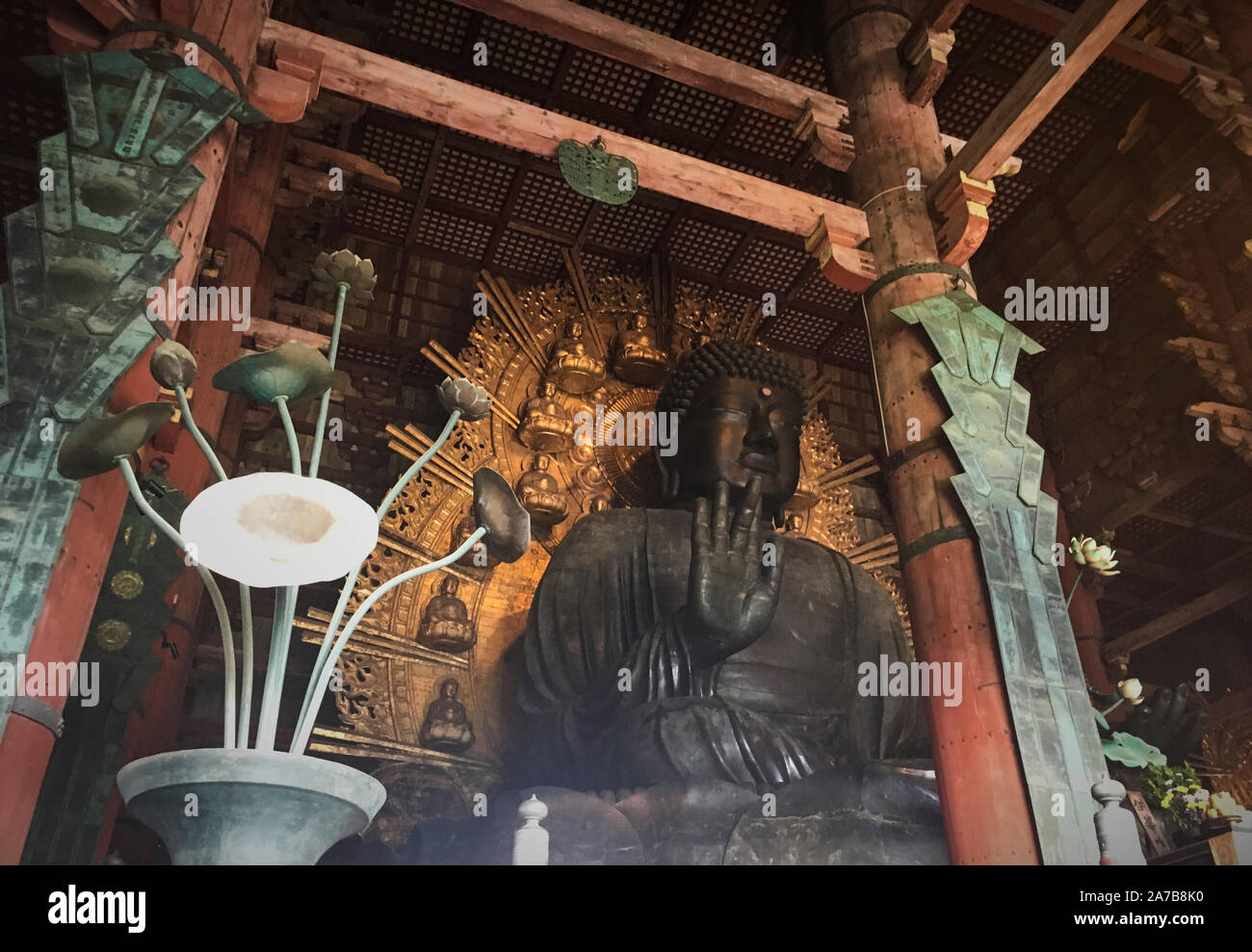 Giant bronze Buddha statue in Todaiji Temple, Nara Park, Japan. The 15 meter tall Buddha represents Vairocana and is flanked by two Bodhisattvas Stock Photo