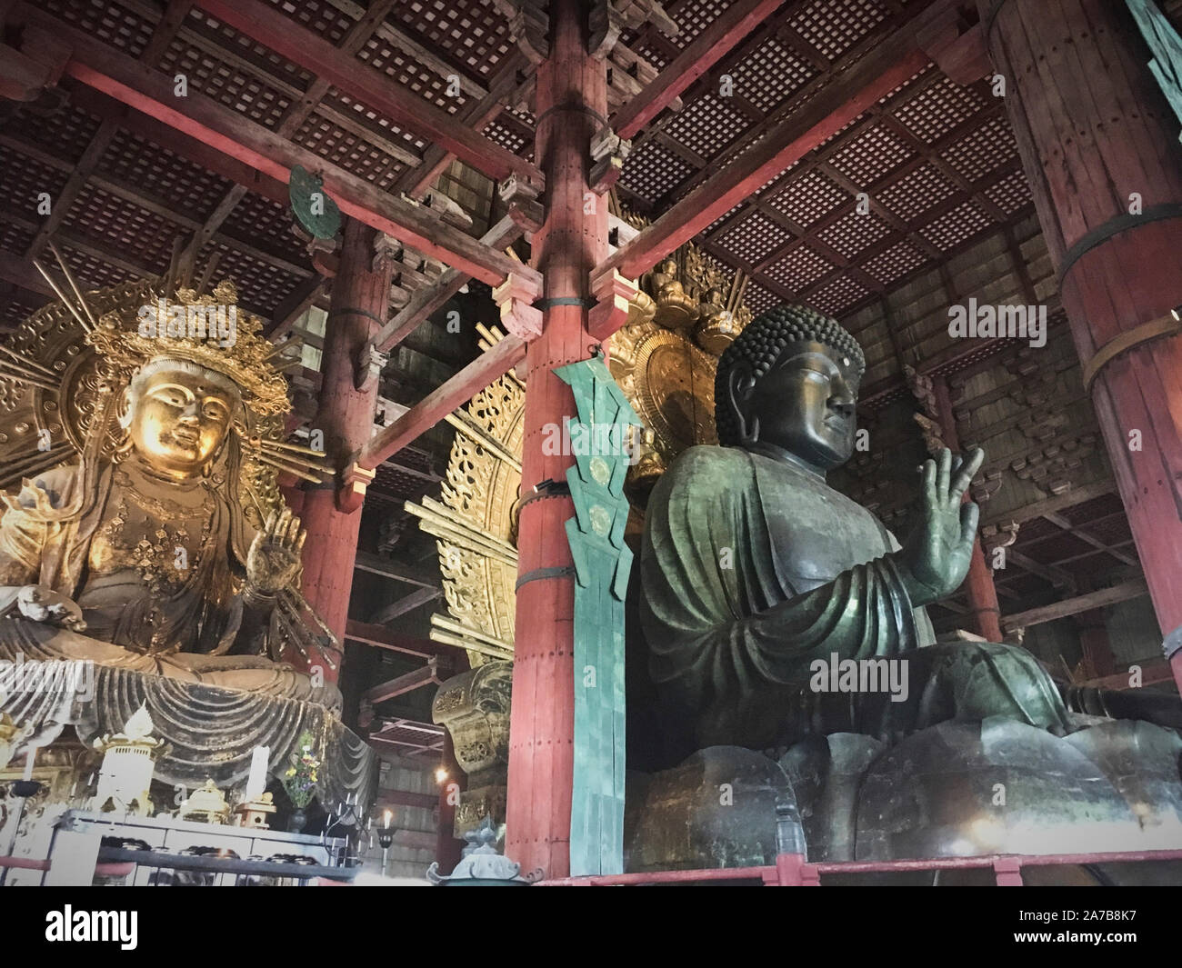 Giant bronze Buddha statue in Todaiji Temple, Nara Park, Japan. The 15 meter tall Buddha represents Vairocana and is flanked by two Bodhisattvas Stock Photo