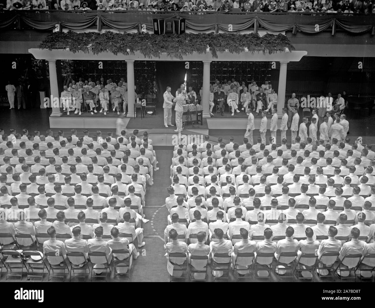 Graduation day at Annapolis. Annapolis, MD, June 3. 319 midshipmen received their diplomas and the degree of Bachelor of Science today before a cheering crowd of undergraduates, parents, friends, and sweethearts assembled in the huge Naval Academy Armory, Chief of the Bureau of Navigation Adolphus Andrews is shown presenting the diplomas, 6/3/37 Stock Photo