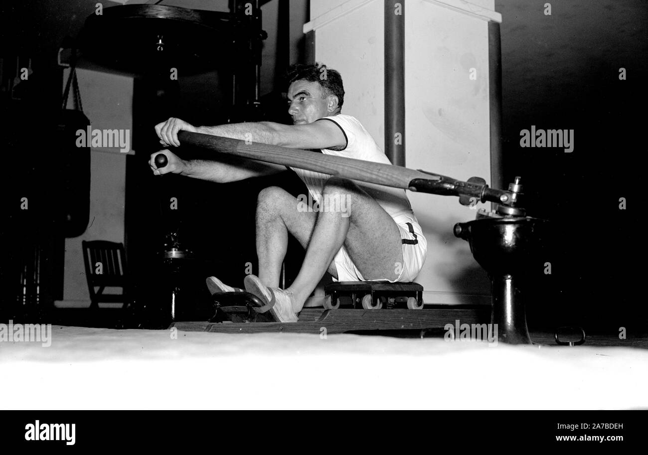 Historical Exercise - Man using a rowing machine ca. 1937 Stock Photo