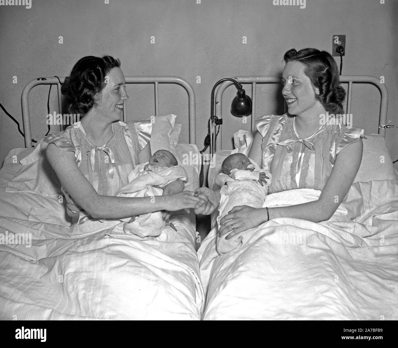 The mothers, Mrs. Eileen Moon, left, and Mrs. Kathleen Robie, last week gave birth to daughters to set a new record at Columbia Maternity Hospital. Mrs. Moon's youngster, whom she named Carol, was born on March 29, while Mrs. Robie's new daughter Nancy Lee first saw the light of day on April 1. This same thing happened in July 1937 when Mrs. Robie gave birth to a girl and a few hours later Mrs. Moon's baby, a boy, arrived Stock Photo