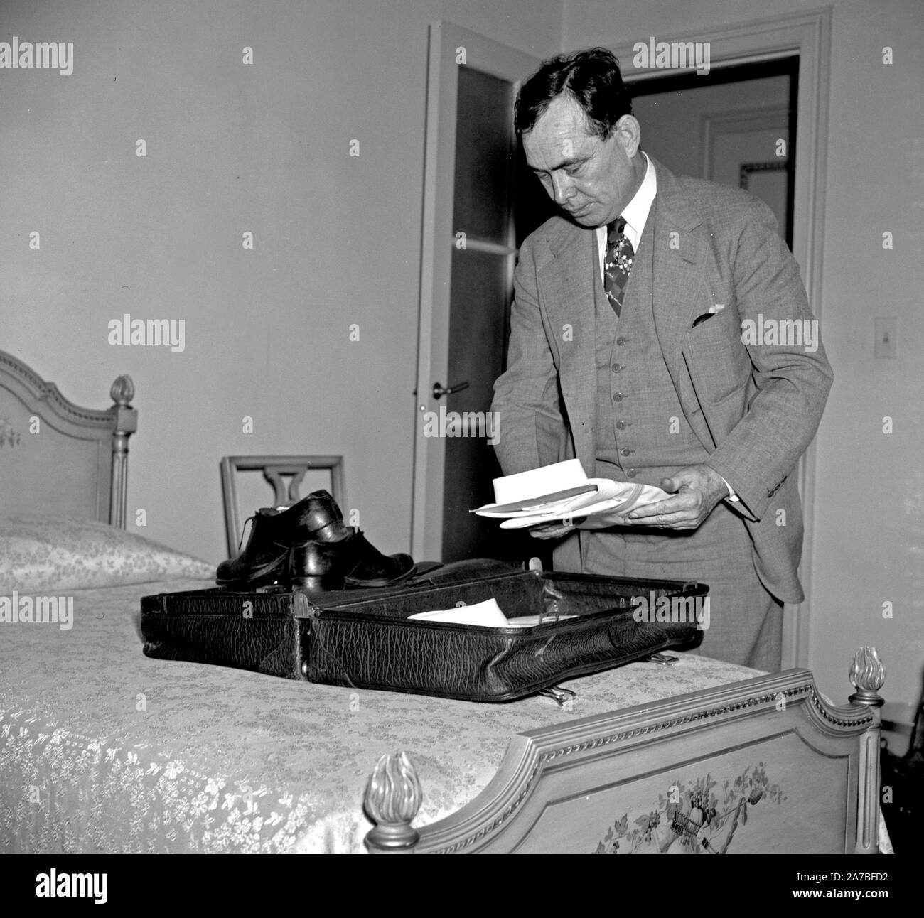 Man packing a suitcase for a trip ca. 1939 Stock Photo