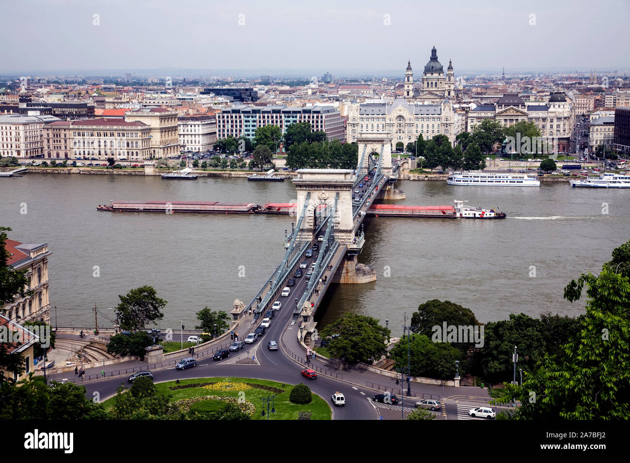 A barge on the Danube River passes under the Chain Bridge (Szechenyi Lanchid) in Budapest. Stock Photo