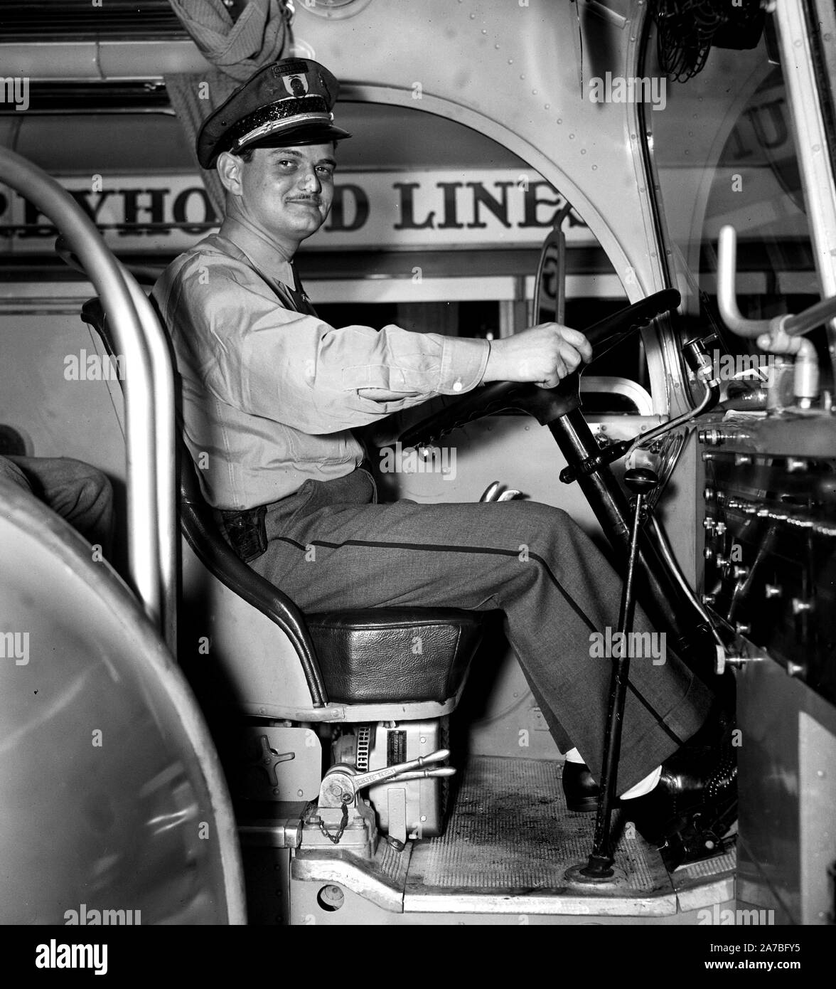 Greyhound Bus lines bus driver sitting at the steering wheel  ca. 1937 Stock Photo