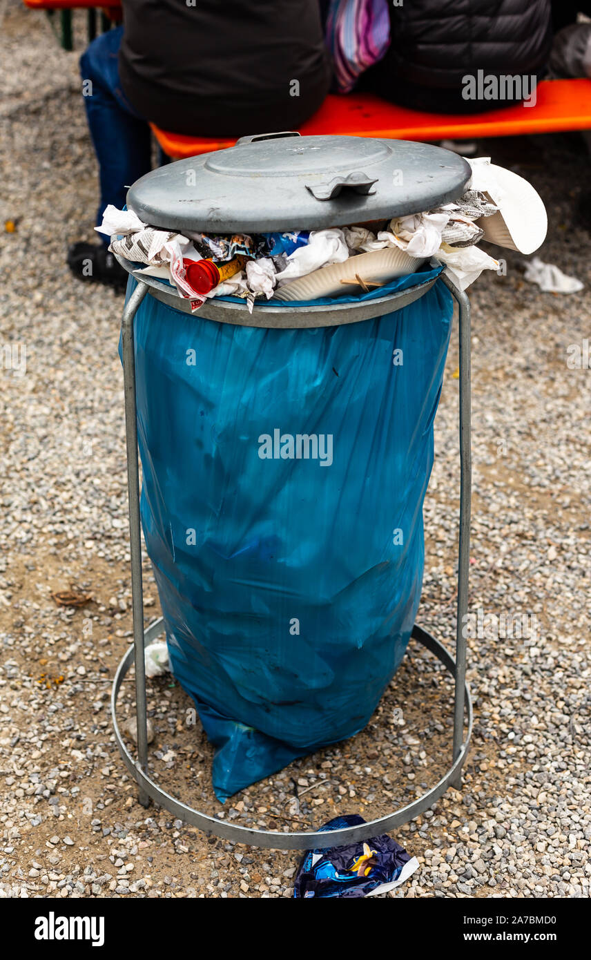 Blue waste bag overloaded with garbage on a folk festival in Germany. Stock Photo