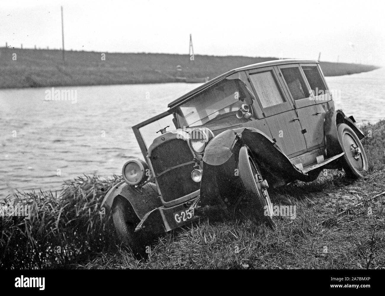 Traffic accident with passenger car on the roadside next to a canal ca