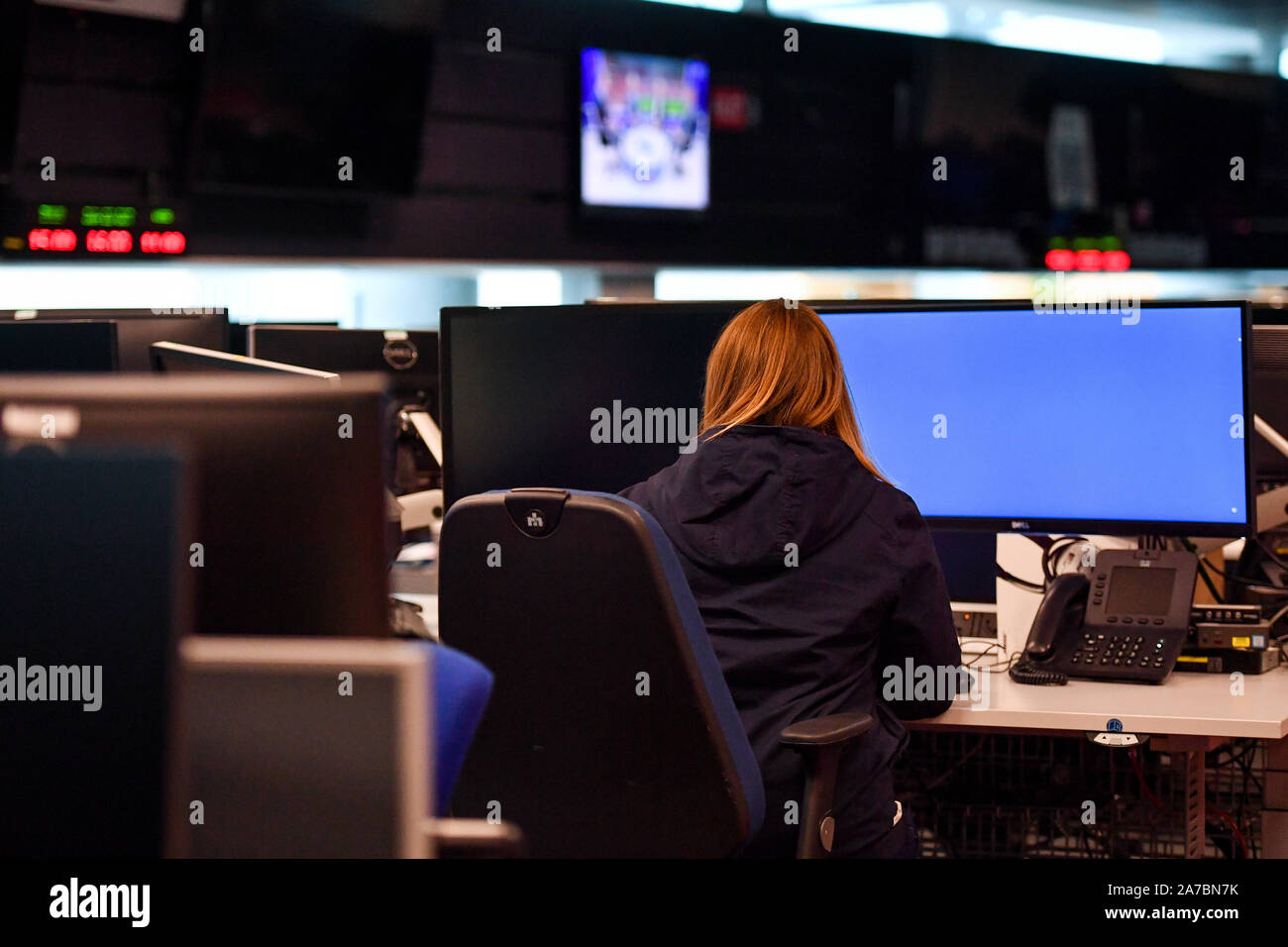 A Woman Sits At A Desk In The Control Room Within Government