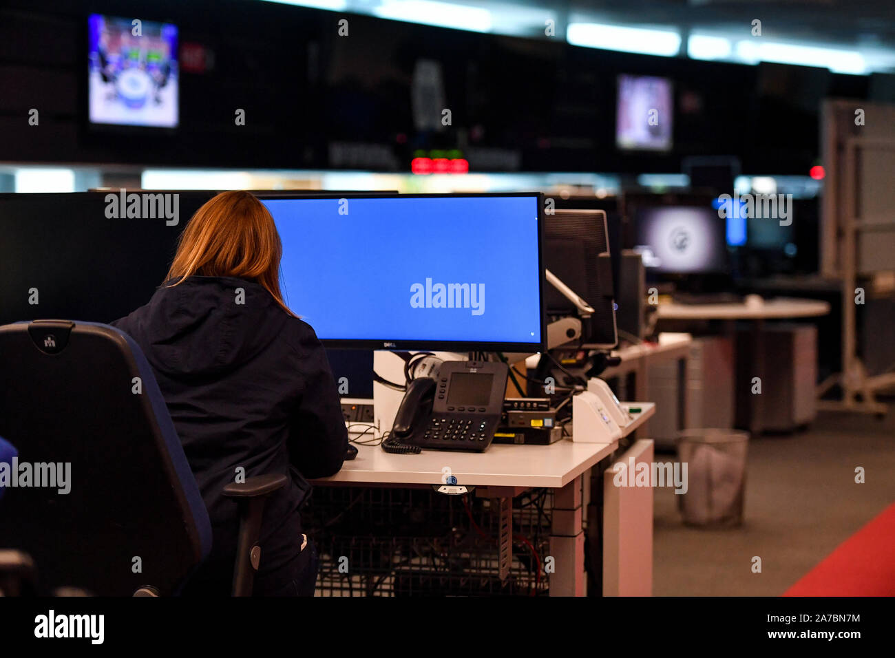 A Woman Sits At A Desk In The Control Room Within Government