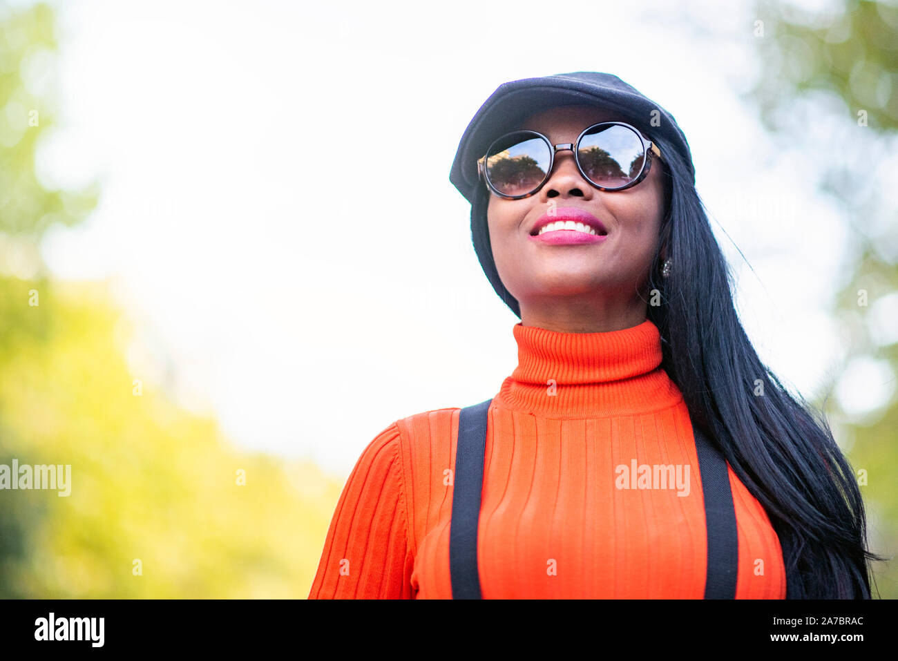 Beautiful brown skinned woman with sunglasses and beautiful smile Stock Photo