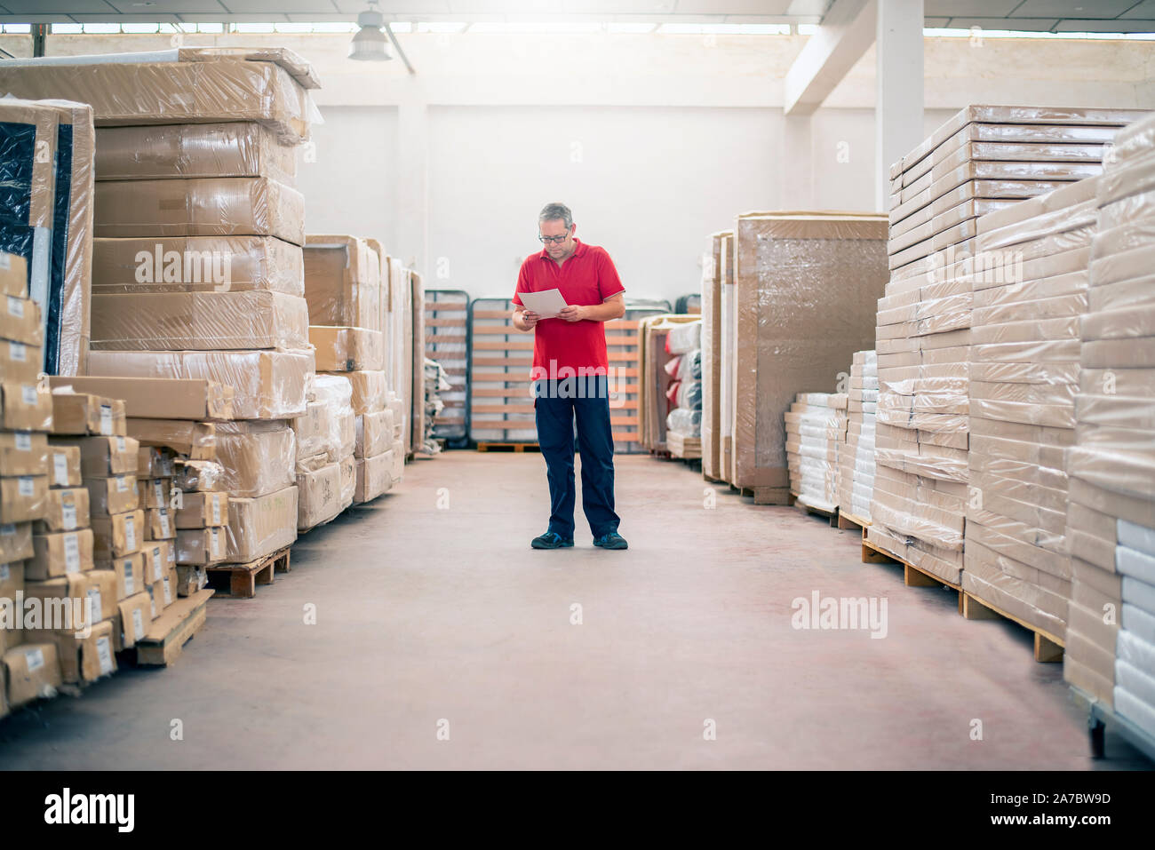 Warehouse employee checking the stock of stored products Stock Photo
