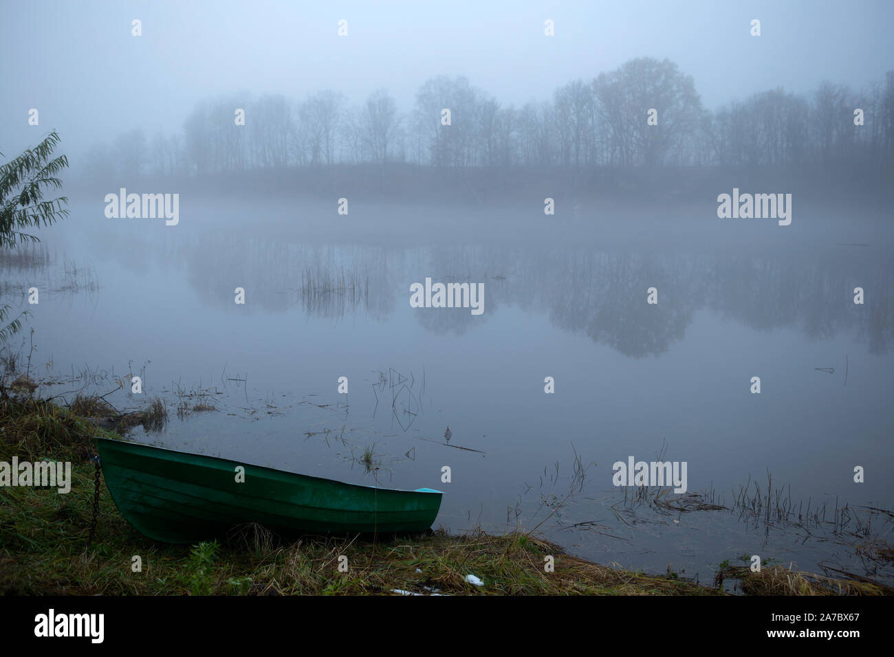 Green boat laying on a river bank Stock Photo - Alamy