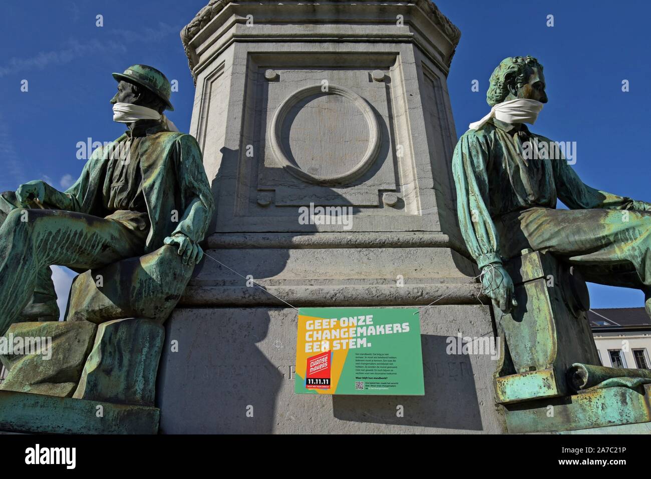 John Cockerill Monument in Place De Luxembourg, Brussels, with figures gagged as a campaign against the silencing of people working for change Stock Photo