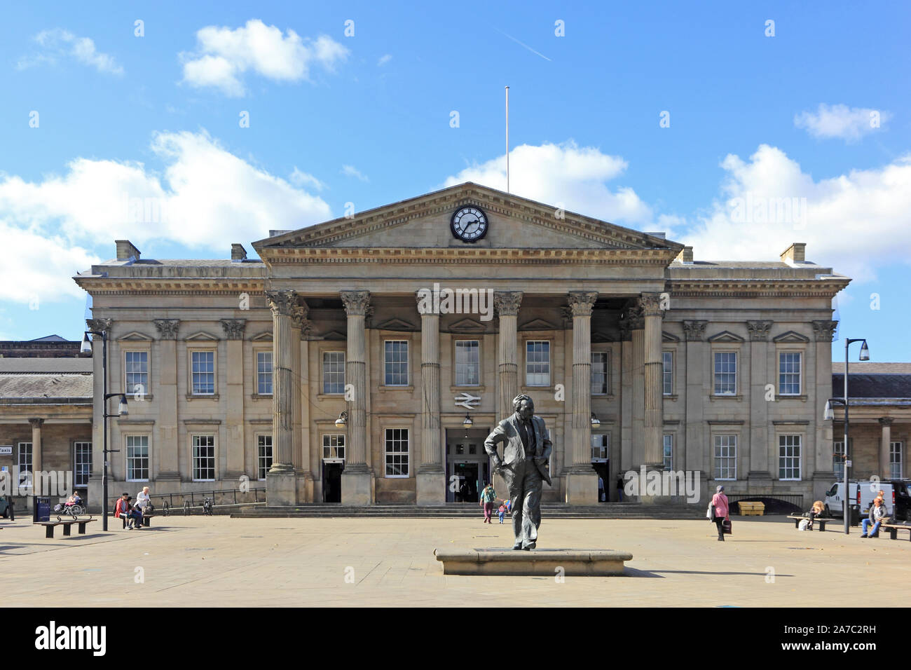Harold Wilson statue, with railway station behind, St George's Square, Huddersfield Stock Photo