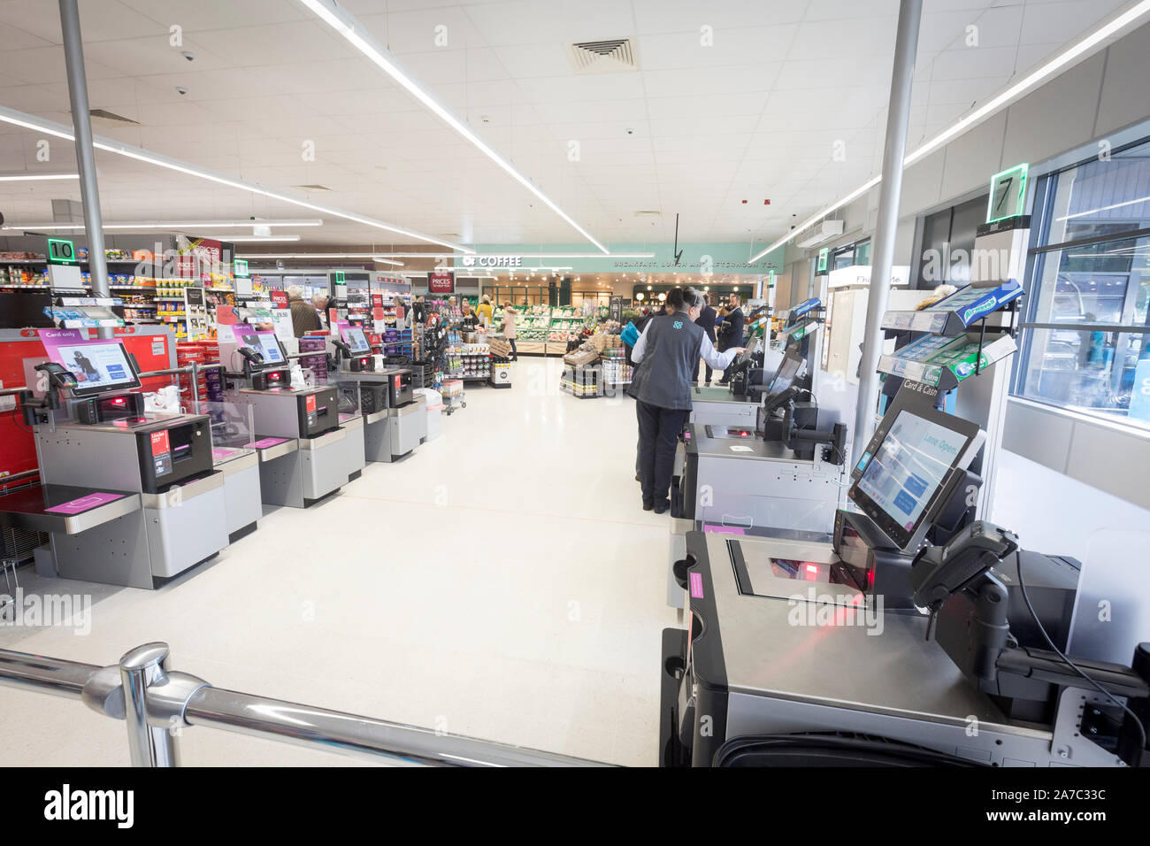 Pictures at a Co-Op food store. A member of staff at work at self service checkouts Stock Photo