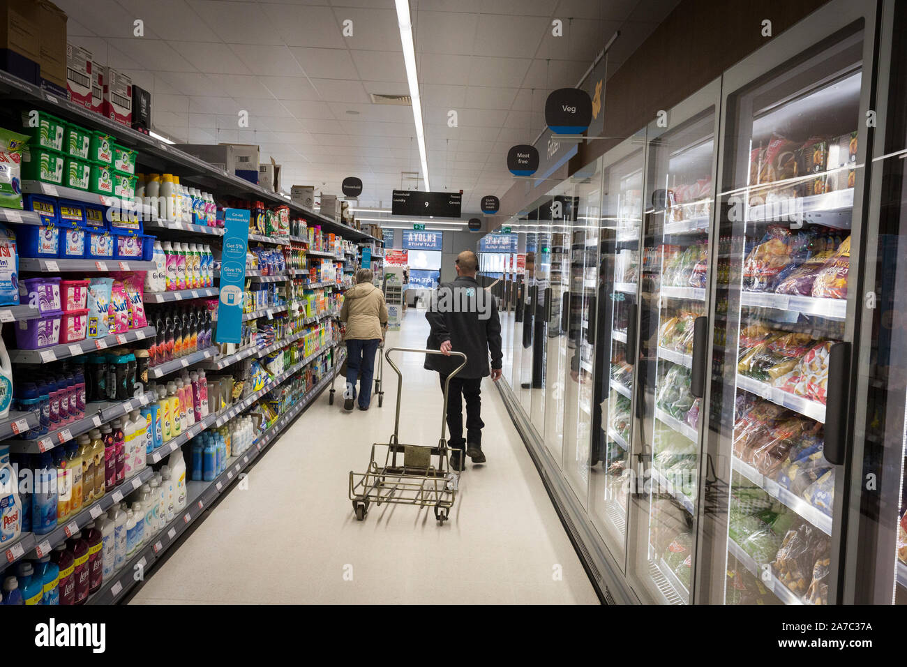Pictures at a Co-Op food store. A male worker pulls a trolley on an aisle Stock Photo