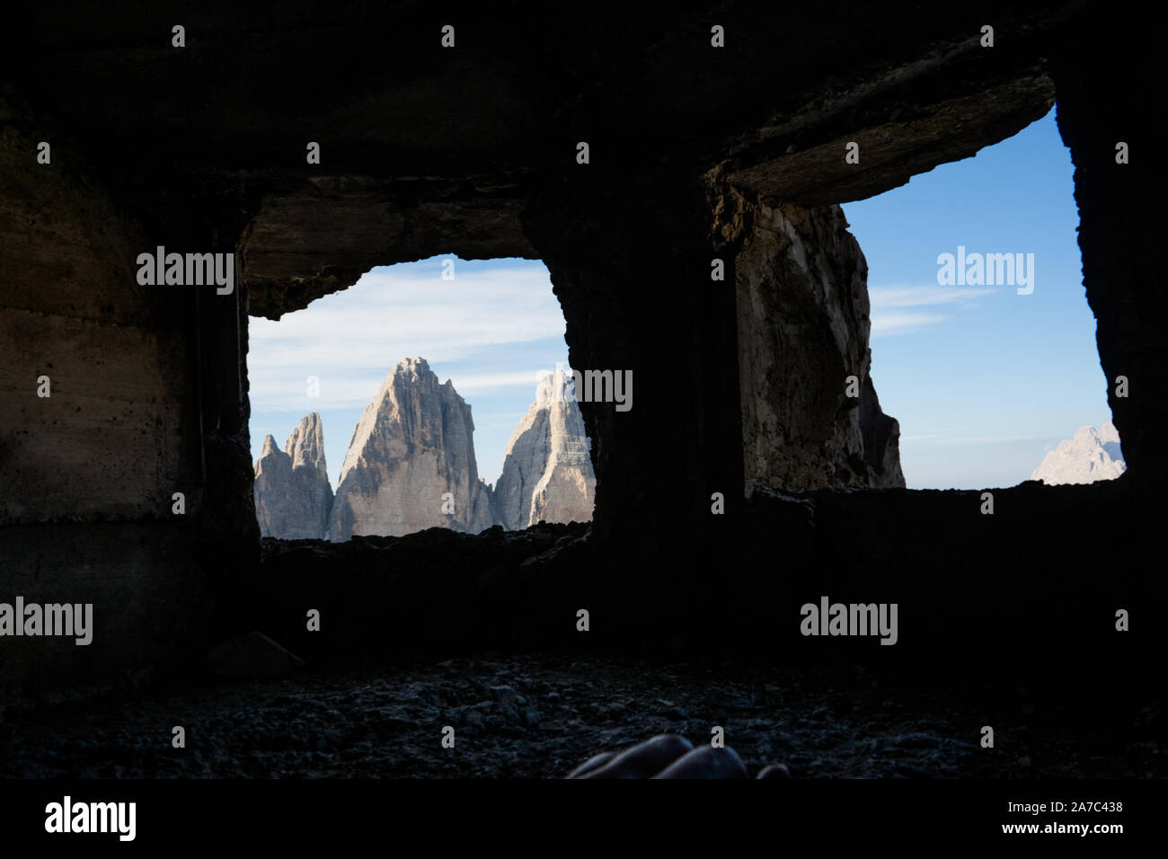 tre cime di (three peaks of) lavaredo peaks as seen from inside a cave where soldiers use to sleep during the second or first world war Stock Photo