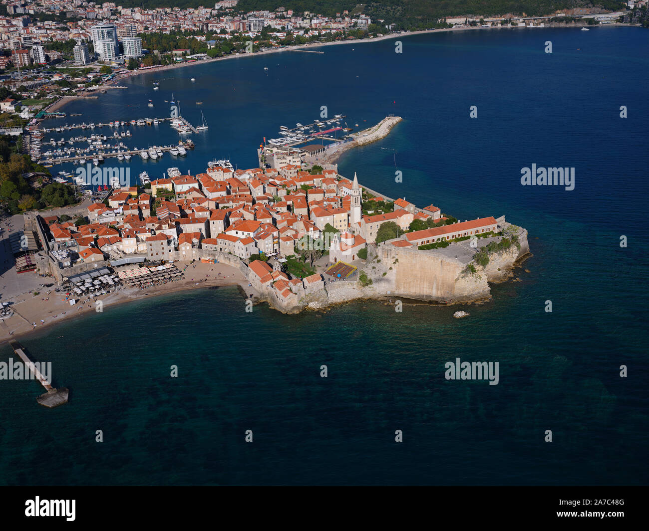 AERIAL VIEW. Medieval town on a rocky promontory. Budva, Montenegro. Stock Photo