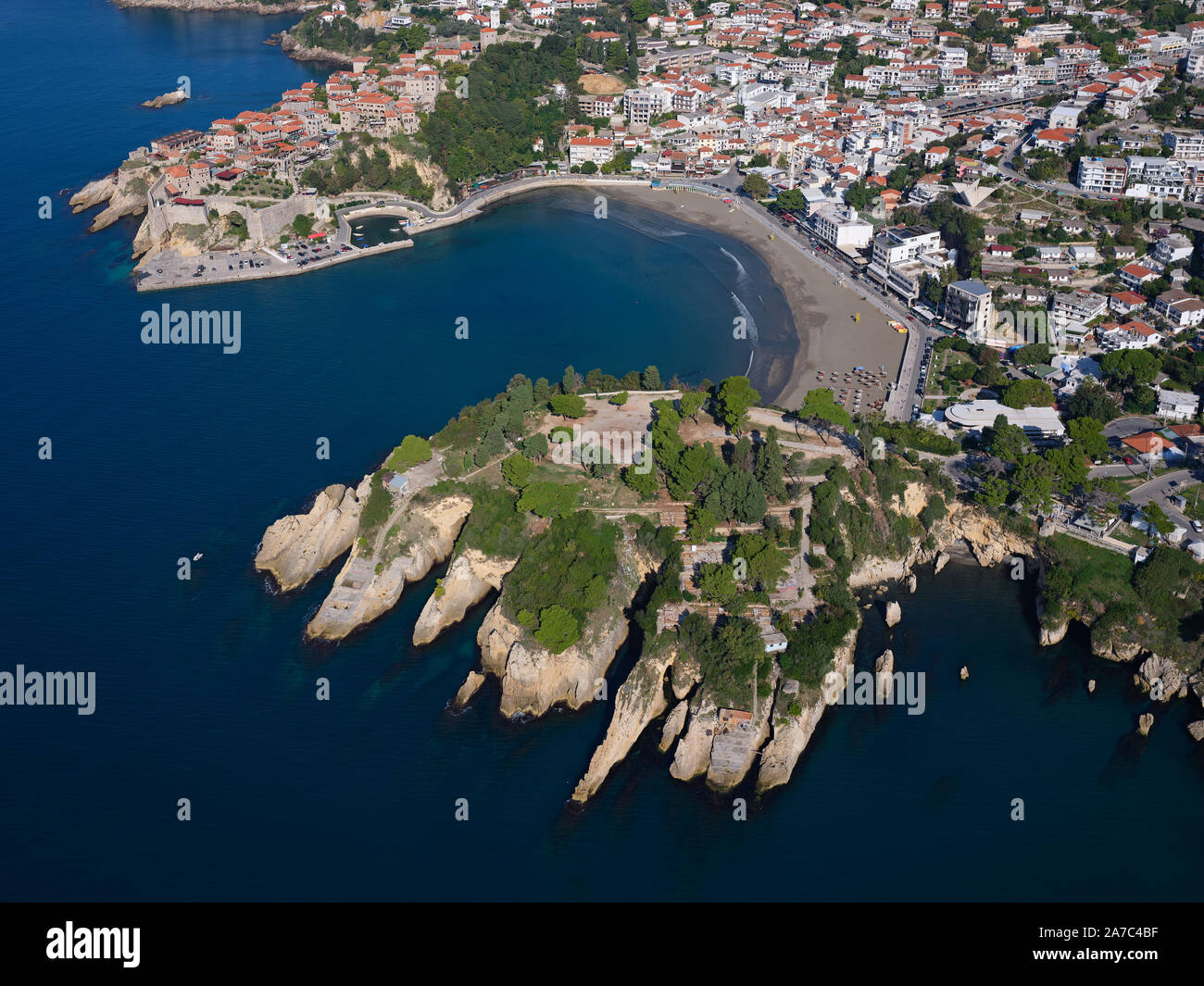 AERIAL VIEW. Historic town on a rocky promontory with a small sheltered bay. Ulcinj, Montenegro. Stock Photo