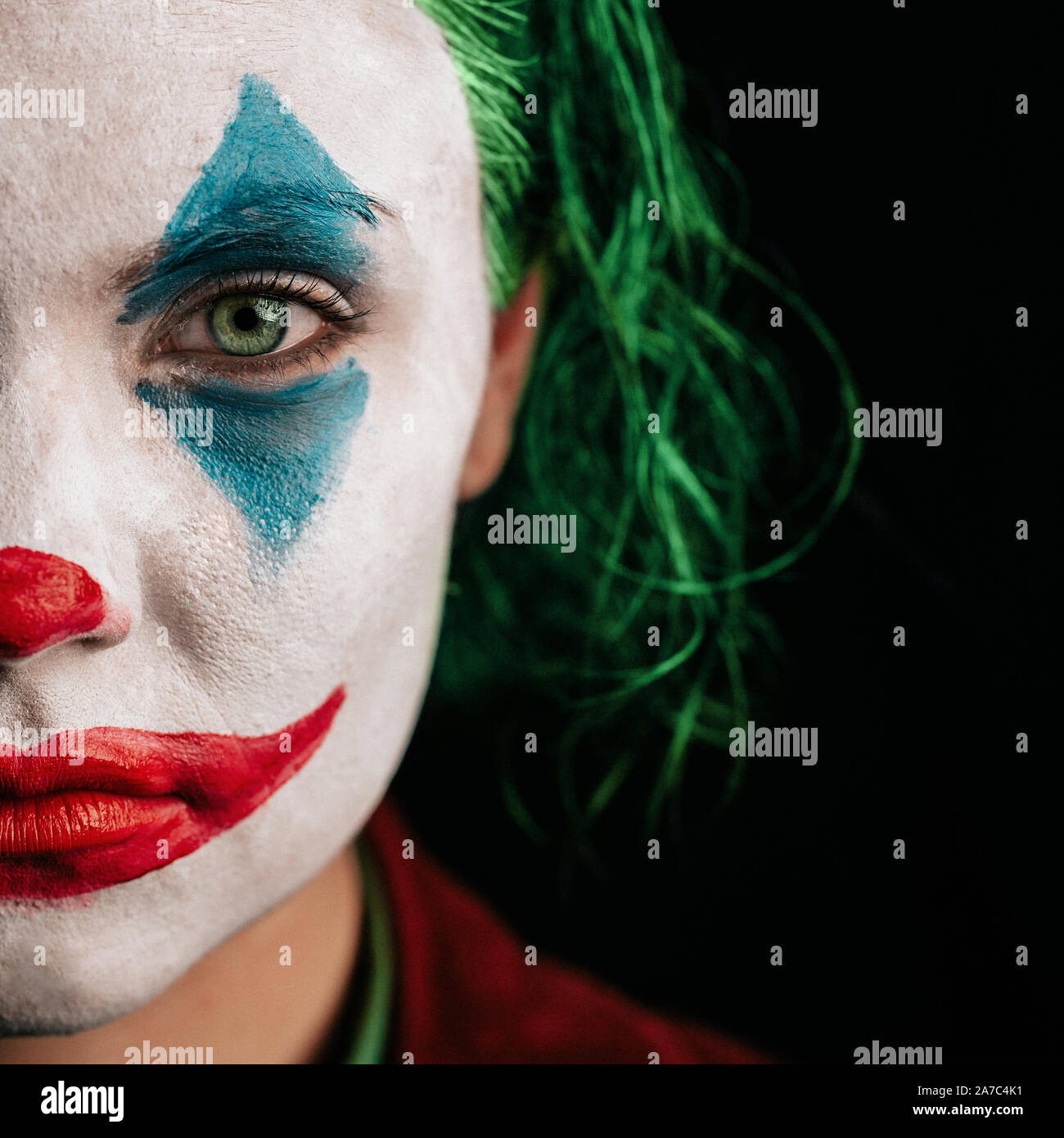 Odessa, Ukraine, 29 October 2019. Make-up Joker with green hair for Halloween. Close-up face on black background.  Stock Photo
